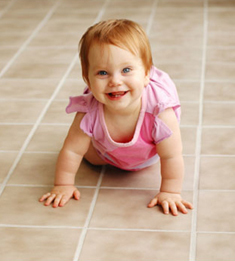 Little girl crawling on a fresh clean tile floor